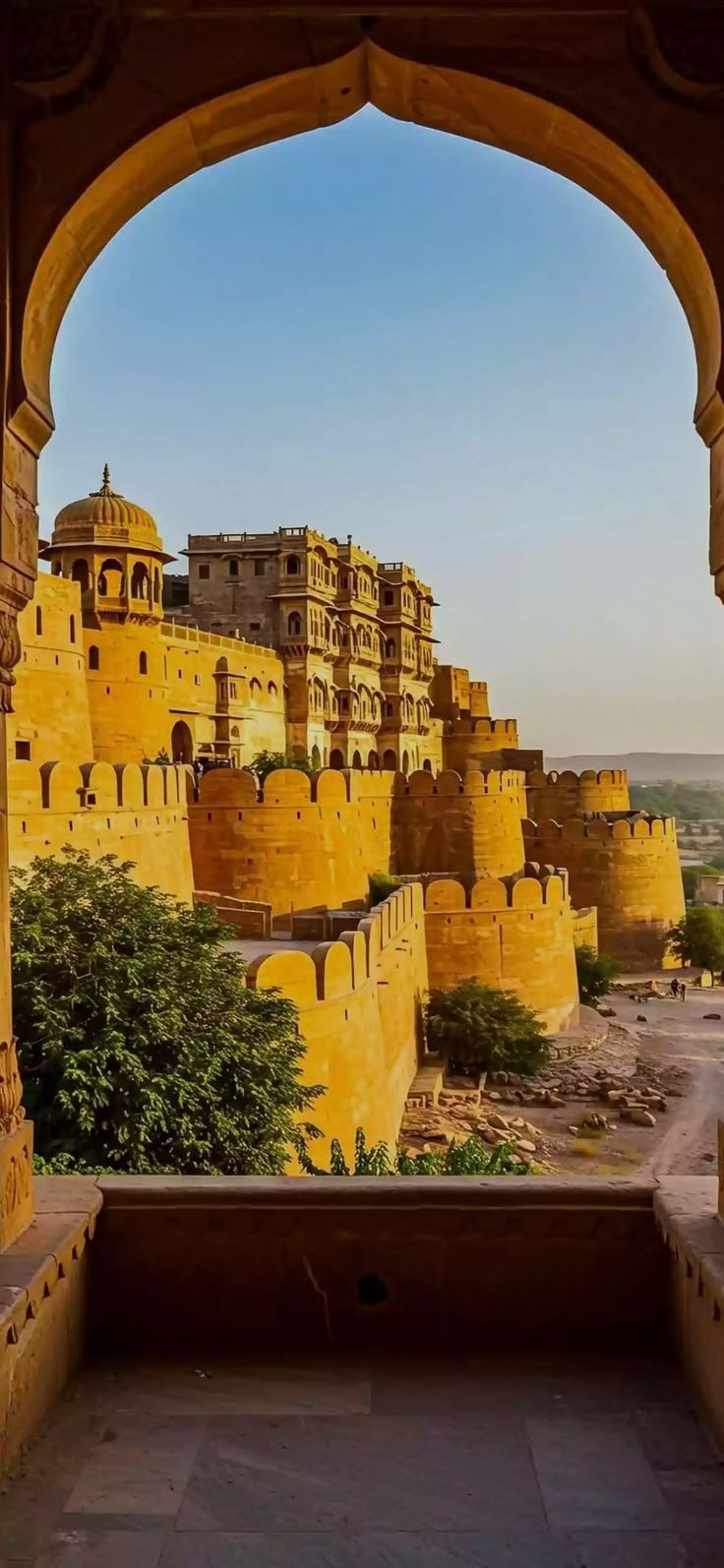 This may contain: an archway leading to a yellow castle in india