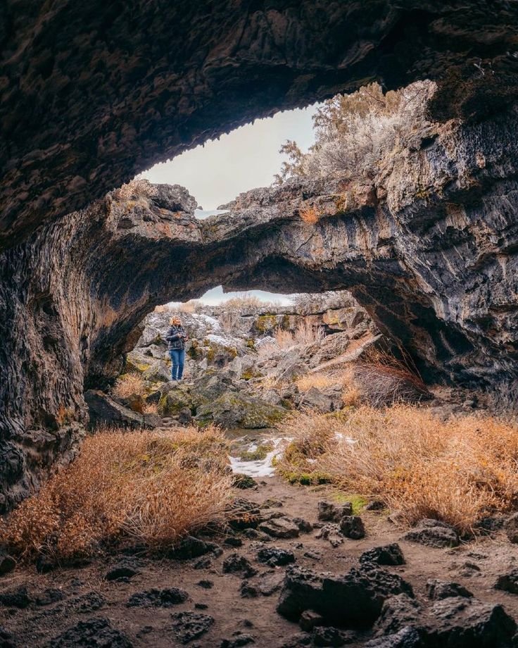 This may contain: a person standing in the middle of a cave