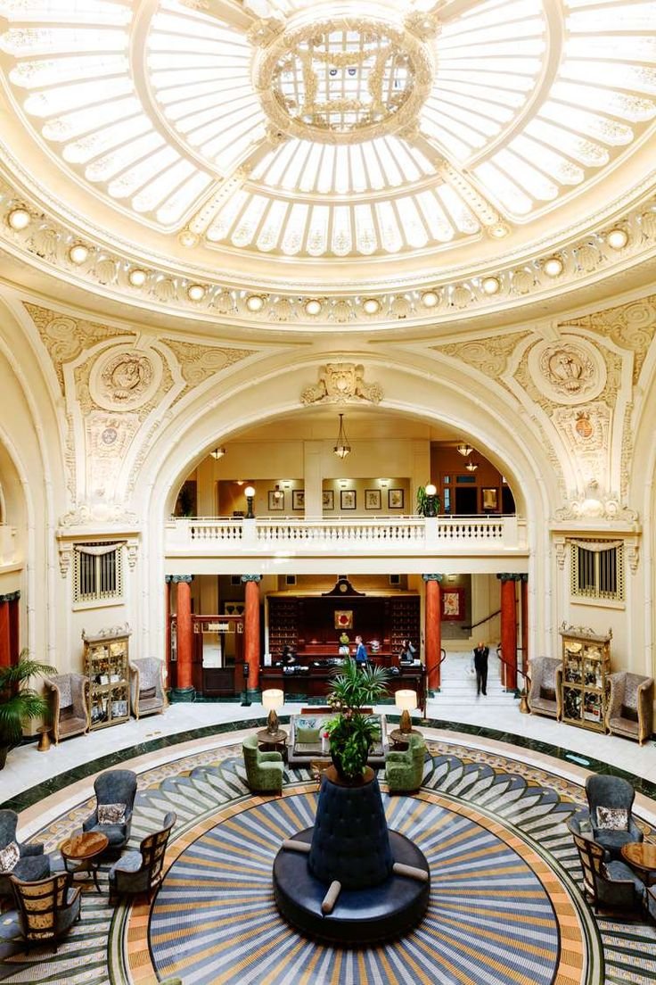 This may contain: an ornately decorated lobby with high ceilings and large circular glass dome above the seating area