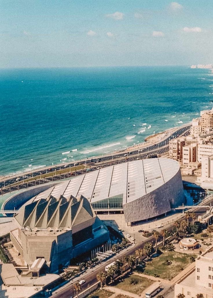 This may contain: an aerial view of a city next to the ocean with buildings and beach in the background