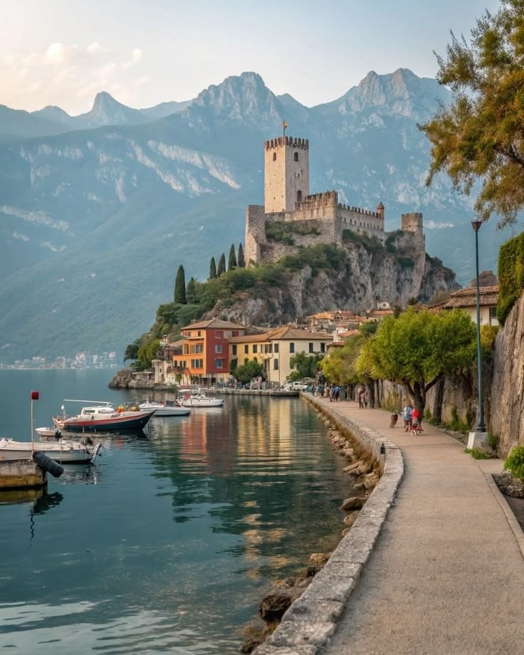 This may contain: an old castle sits on top of a hill next to the water