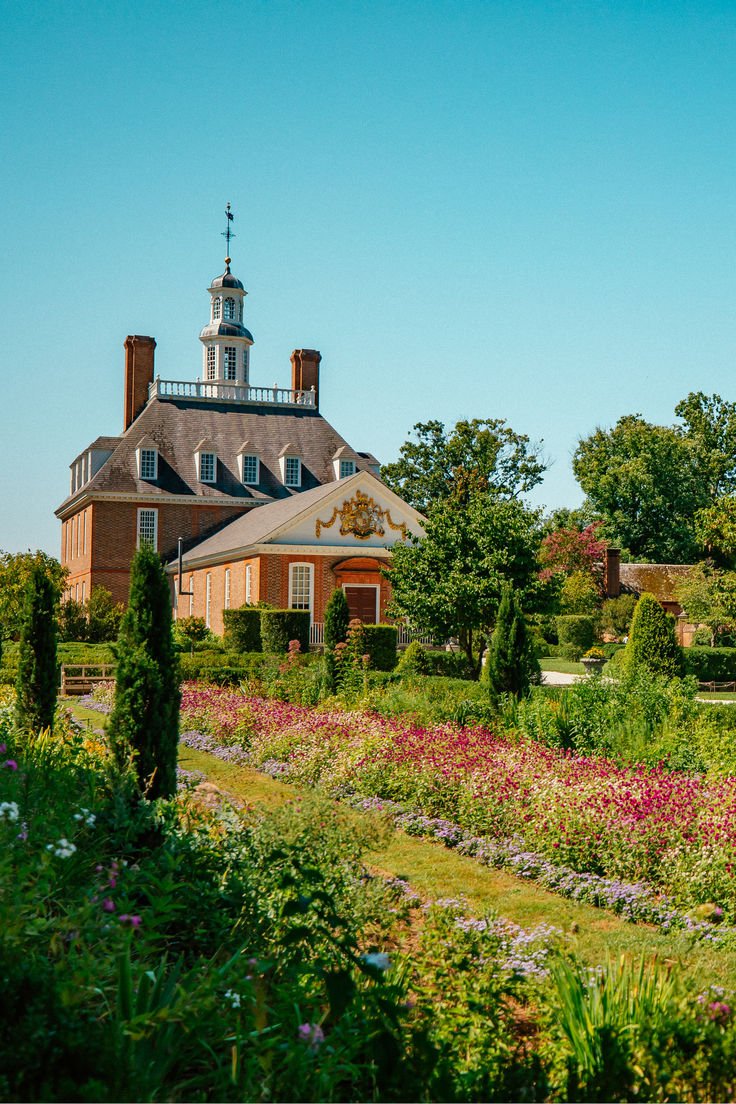 This may contain: a large building with a clock tower in the middle of it's garden area