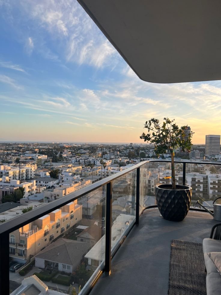 This may contain: a balcony overlooking the city at sunset