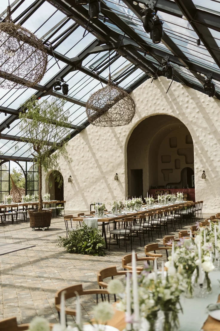 This may contain: the inside of a building with tables and chairs set up for a formal dinner or party