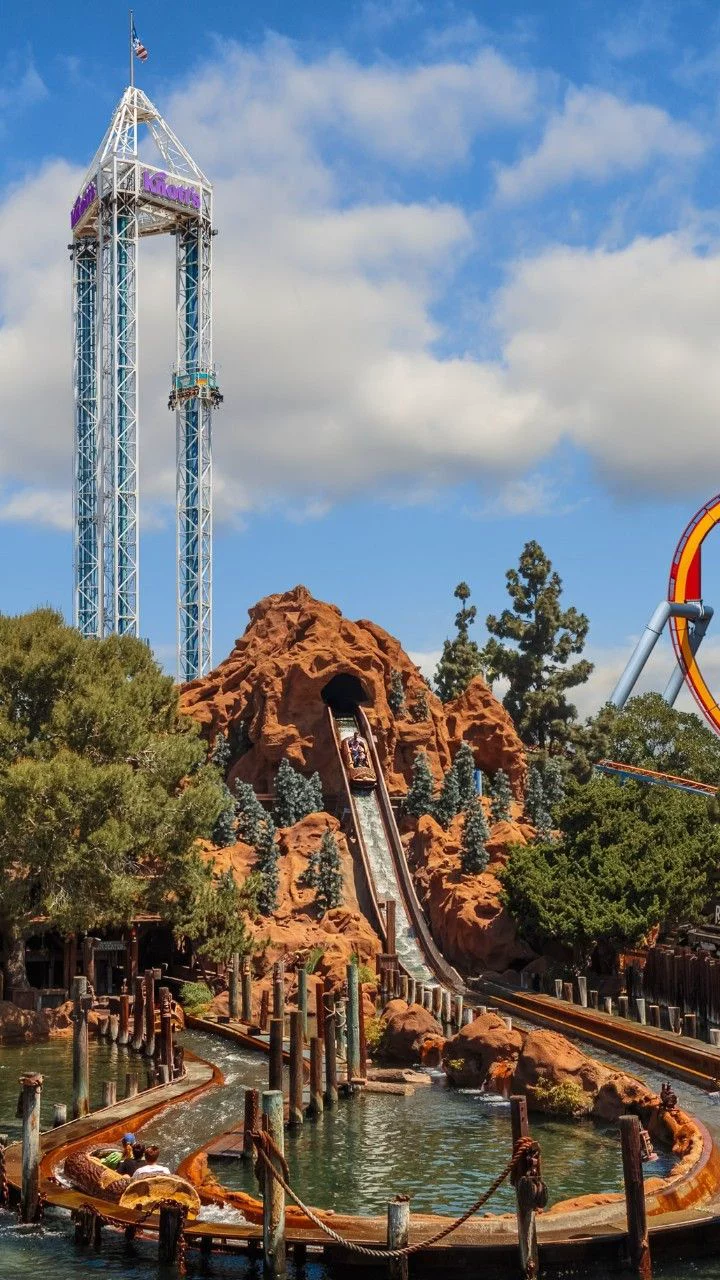 This may contain: an amusement park with a roller coaster and water slide