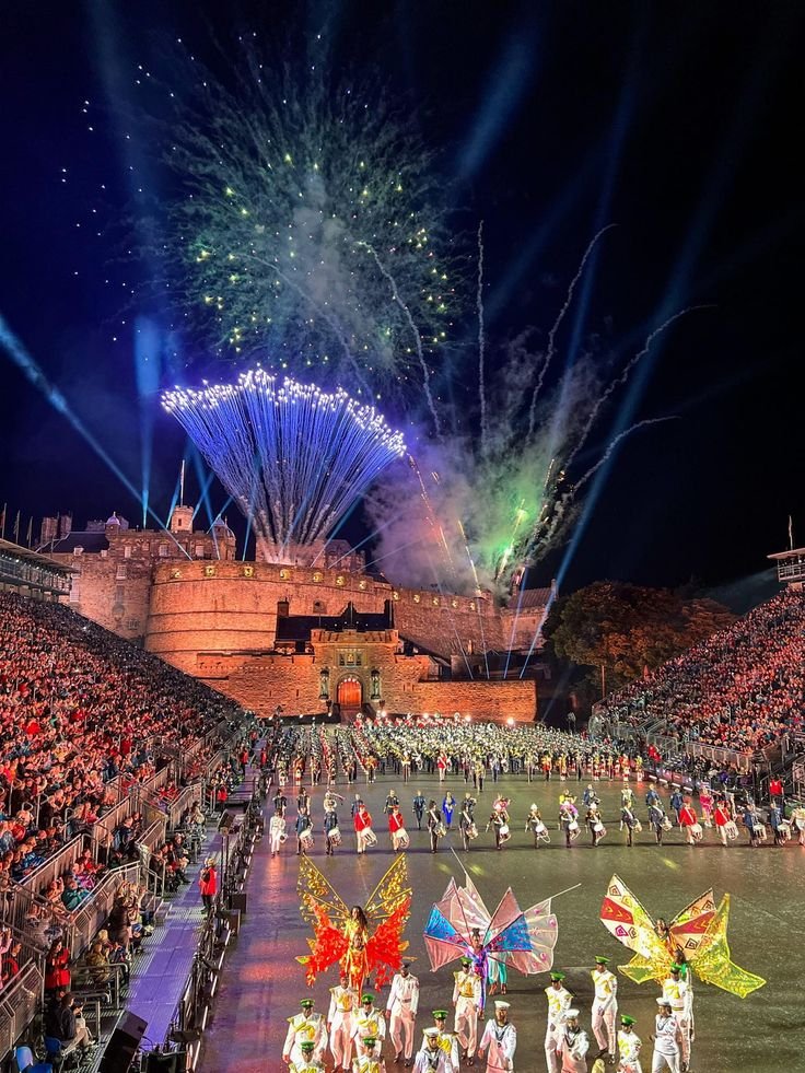 This may contain: a group of people standing on top of a stage with flags and fireworks in the sky