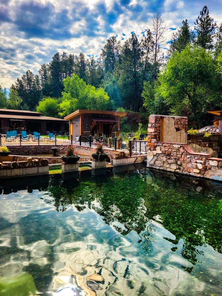 This may contain: there is a large body of water in the middle of this park with tables and chairs around it