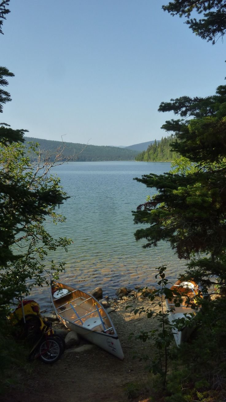 This may contain: a canoe sitting on the shore of a lake
