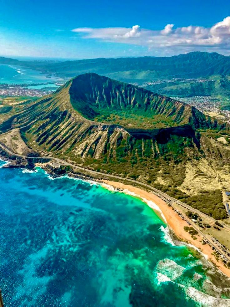 This may contain: an aerial view of the ocean and mountains in hawaii, with clear blue water below
