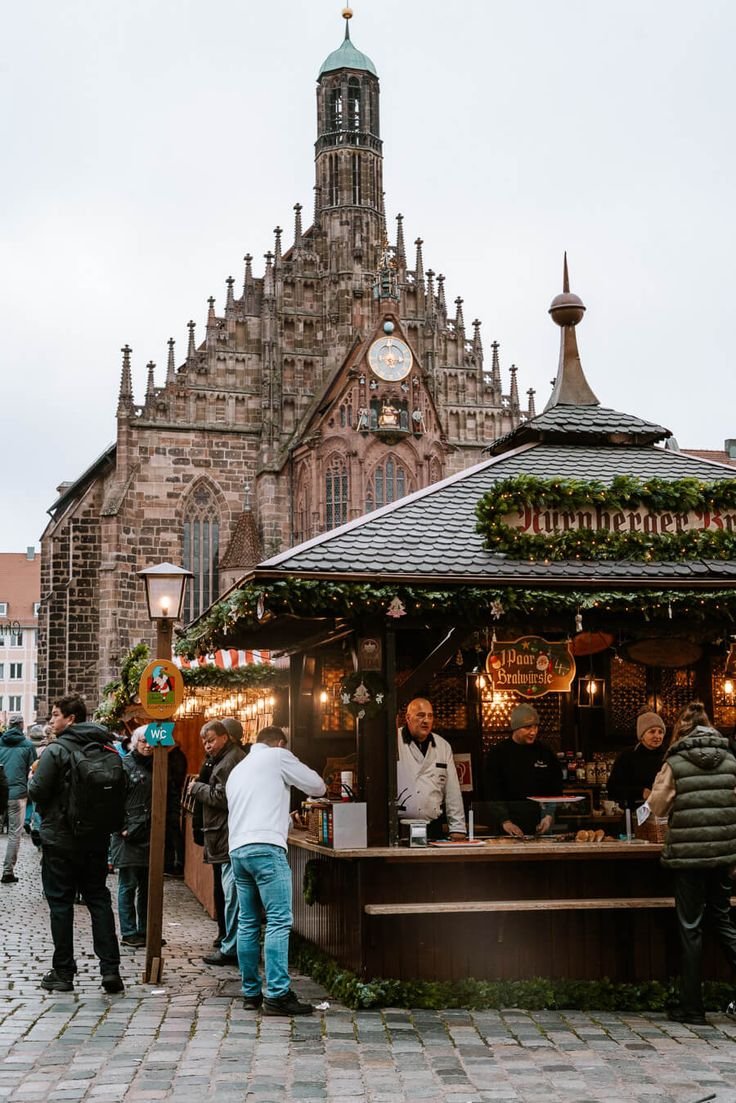 This may contain: people are walking around in front of an old building with a clock on the tower