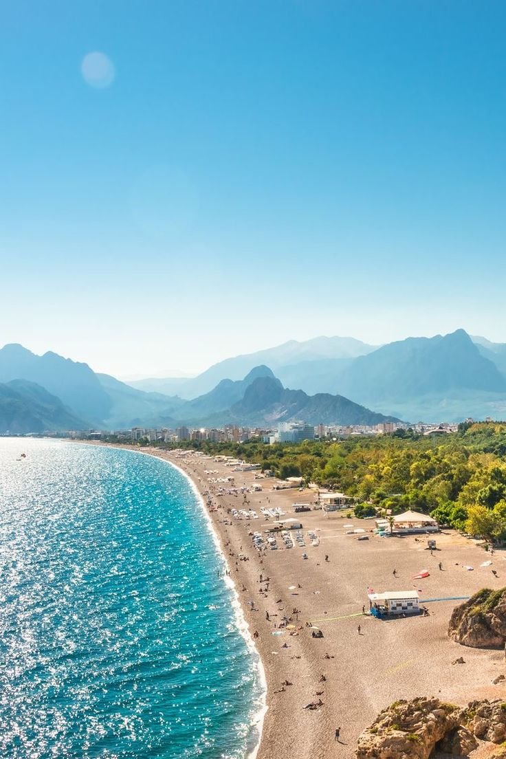 This may contain: an aerial view of a beach with mountains in the background