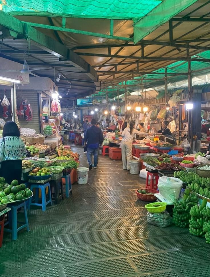 This may contain: an open air market with lots of fruits and vegetables