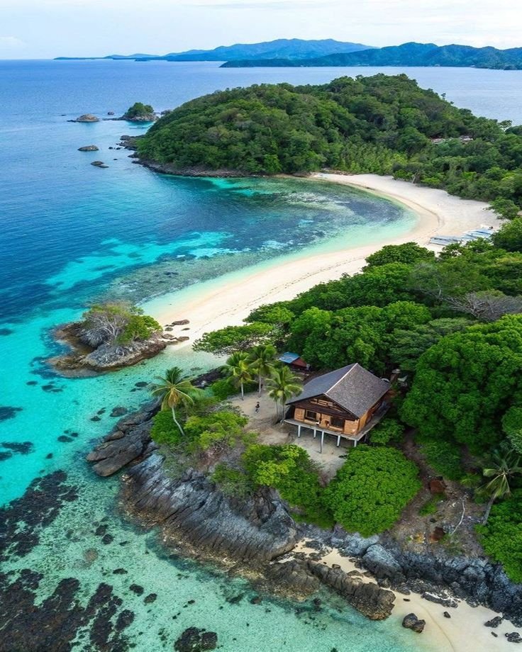 This may contain: an aerial view of a tropical island with white sand and blue water