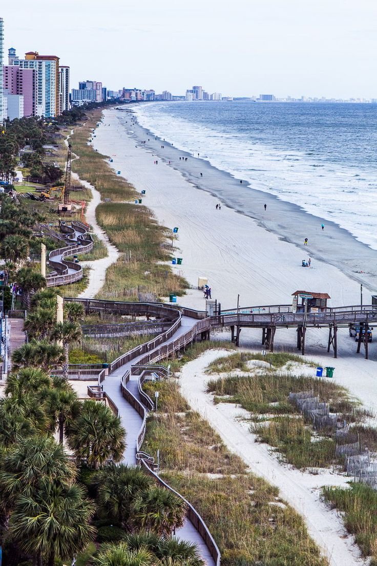 This may contain: the beach is lined with palm trees and boardwalks