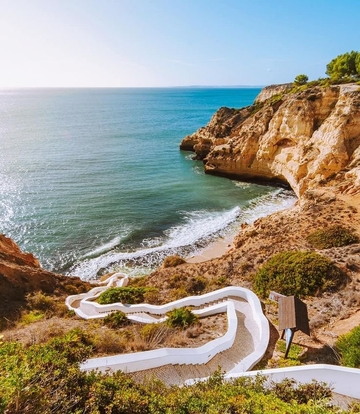 This may contain: the stairs lead down to the beach from the cliff above it are painted with white paint