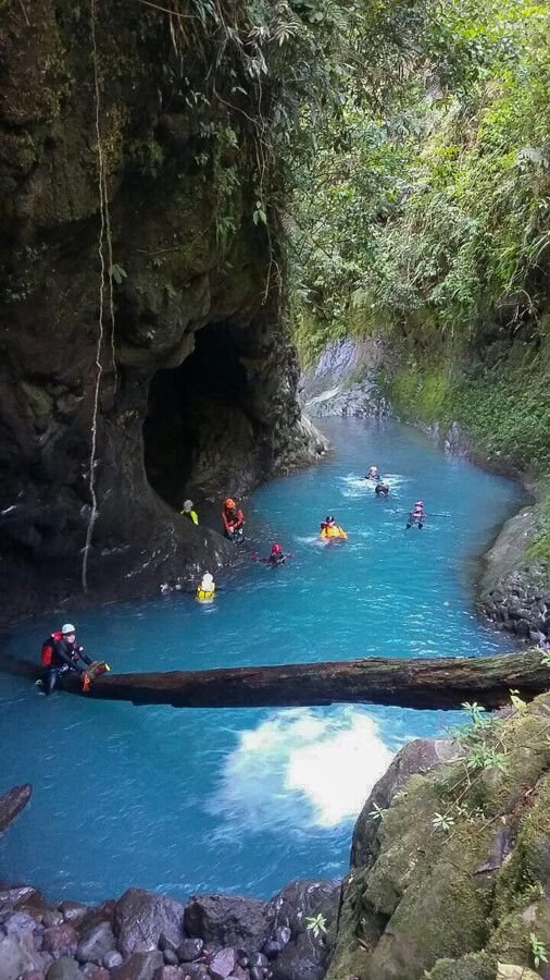 This may contain: several people are rafting down a river in the jungle with blue water and green trees