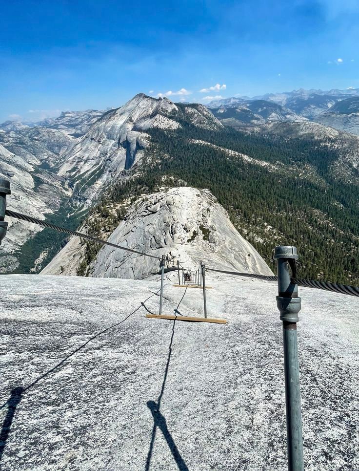 This may contain: a ski lift sitting on the side of a snow covered mountain with mountains in the background
