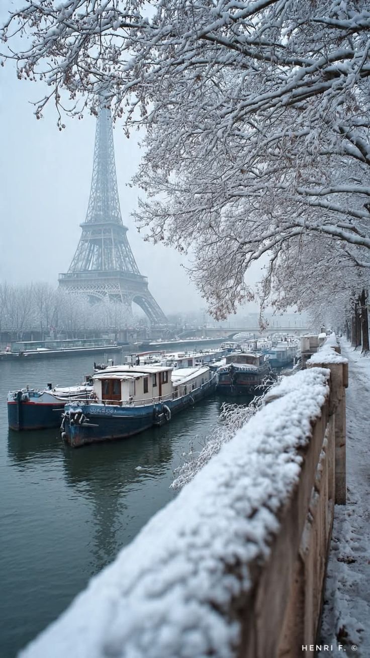 This may contain: the eiffel tower towering over the water in winter