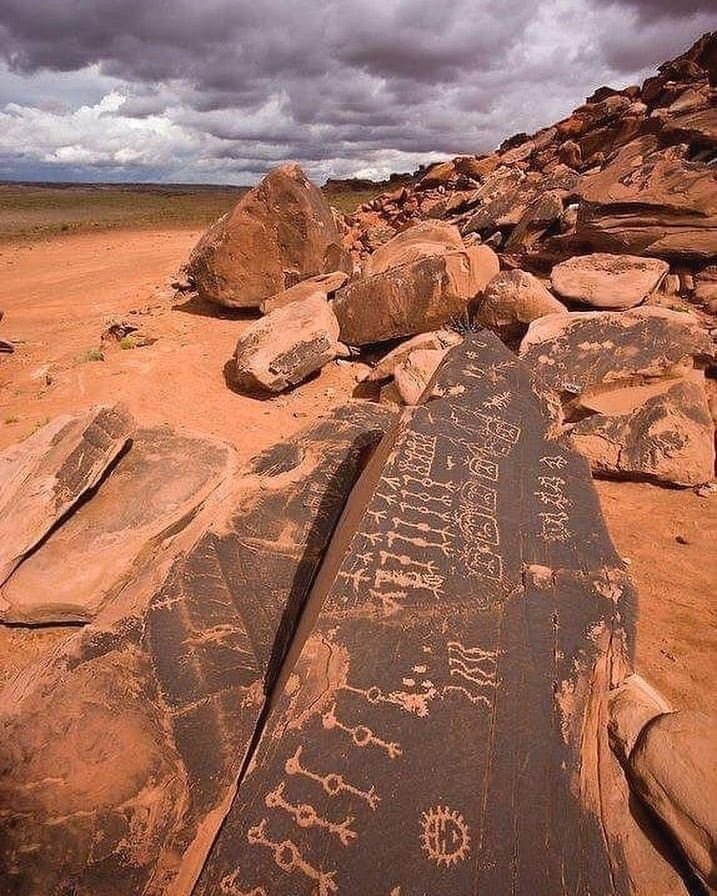 This may contain: some rocks with writing on them in the desert
