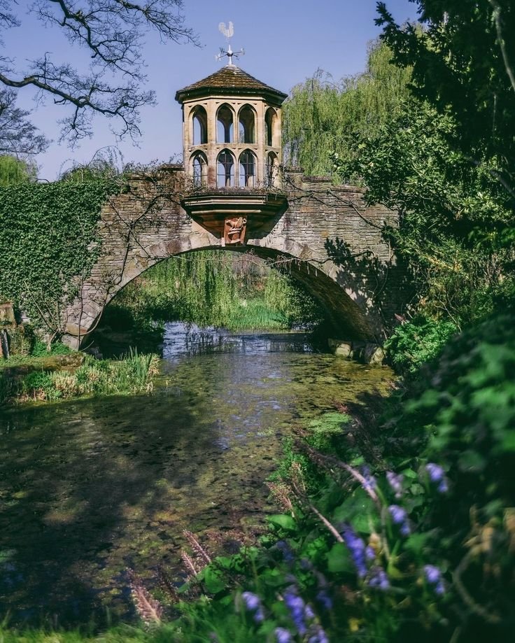 This may contain: an old stone bridge over a small river