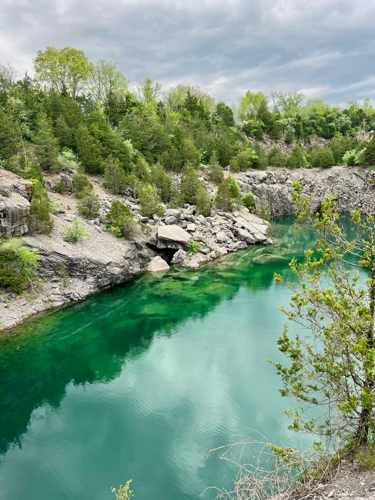 This may contain: the water is very green and blue in this area with some trees on both sides