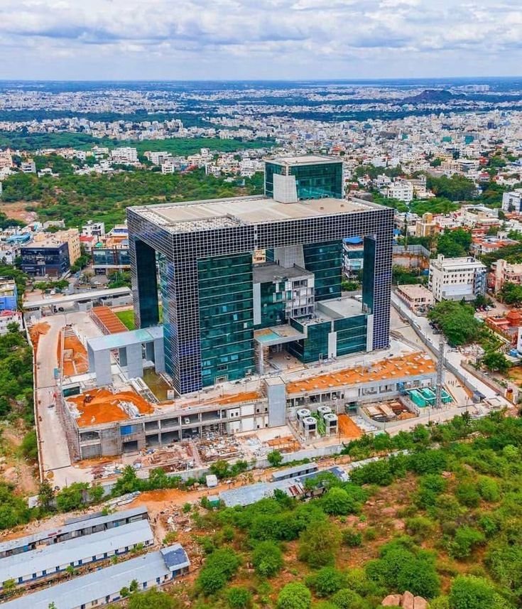 This may contain: an aerial view of a large building under construction in the middle of a city with lots of trees