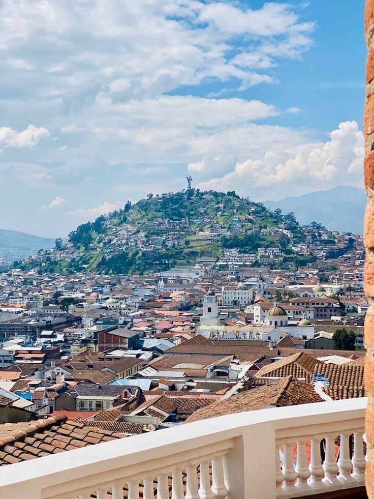 This may contain: a view of a city from the top of a building with mountains in the background