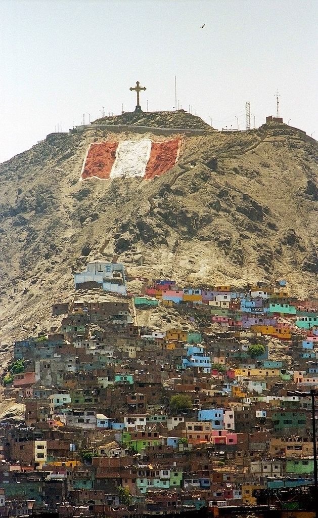 This may contain: a large hill covered in lots of buildings and a cross on top of the hill