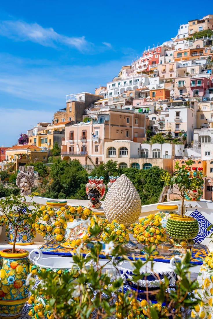 This may contain: many plates and bowls on a table with flowers in front of a cityscape