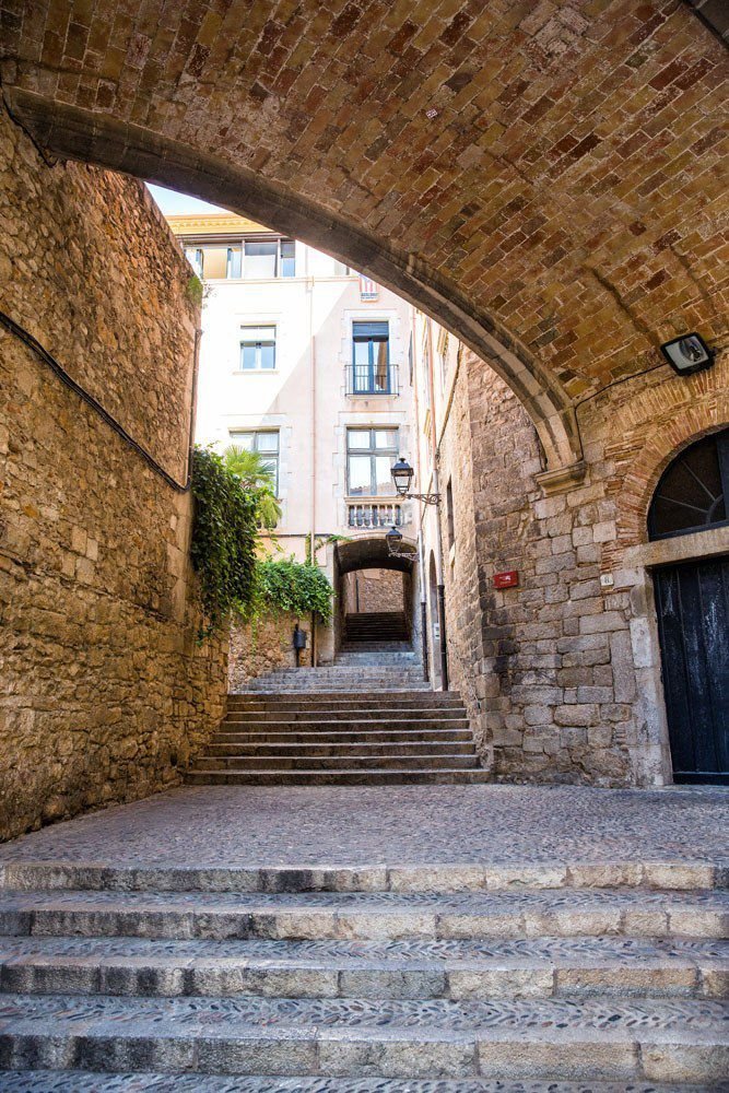 This may contain: an alleyway with stone steps and brick walls