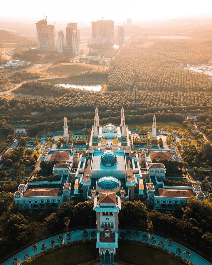 This may contain: an aerial view of a large building in the middle of trees and buildings around it