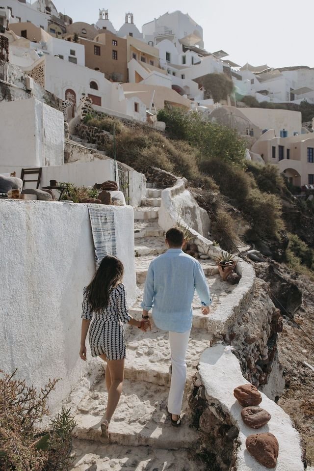 This may contain: a man and woman walking up some steps