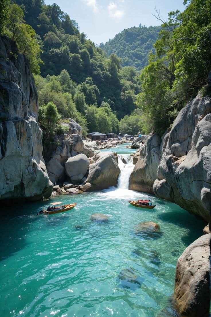 This may contain: two boats floating down a river surrounded by rocks
