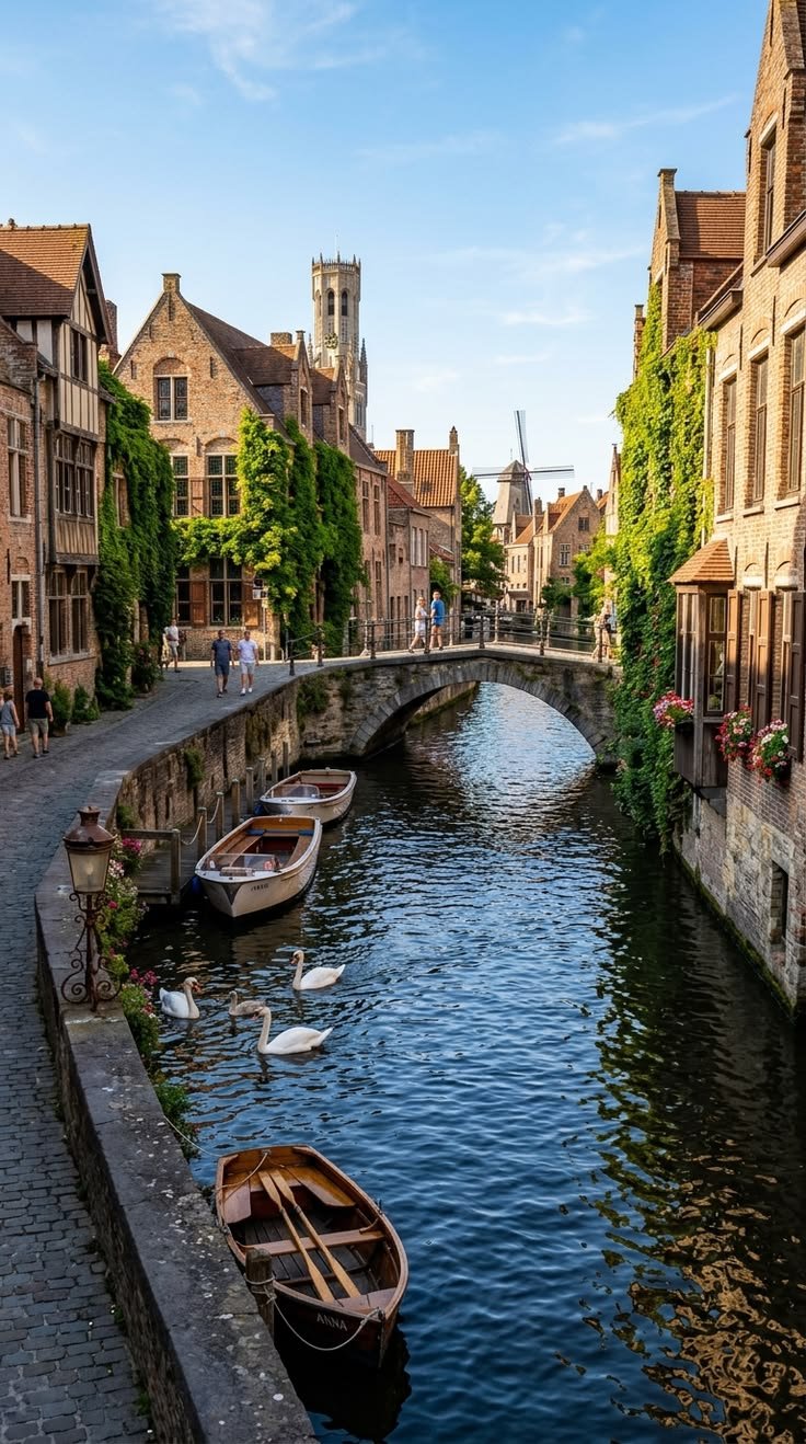 This may contain: two boats are docked on the side of a river in an old european town with stone buildings
