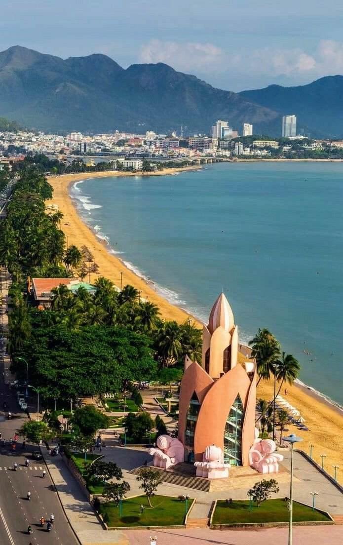 This may contain: an aerial view of the beach and ocean with mountains in the background, including palm trees