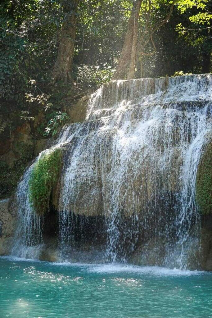 This may contain: a large waterfall with water cascading over it's sides in the jungle
