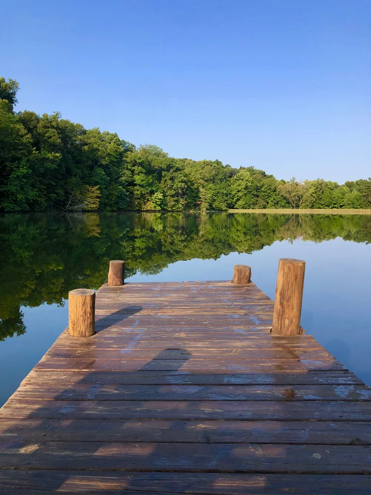 This may contain: a wooden dock sitting on top of a lake
