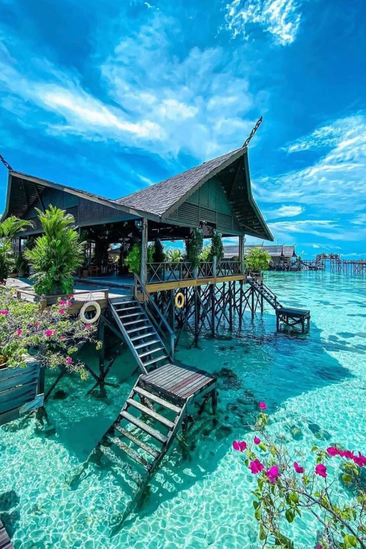 This may contain: the water is crystal blue and clear with some chairs on it in front of a dock
