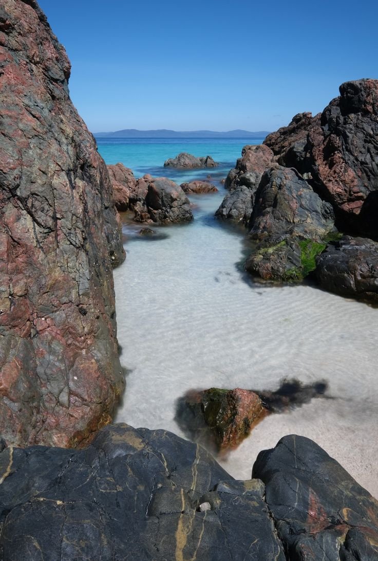 This may contain: some rocks and water on the beach