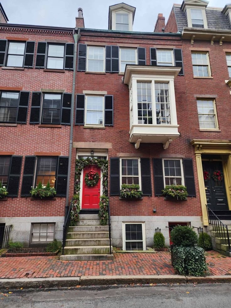 This may contain: an apartment building with red door and black shutters