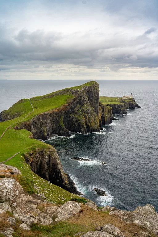 This may contain: an island in the middle of the ocean with grass growing on it's sides