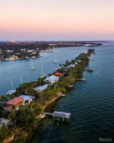 This may contain: an aerial view of a long stretch of water with houses and boats in the distance