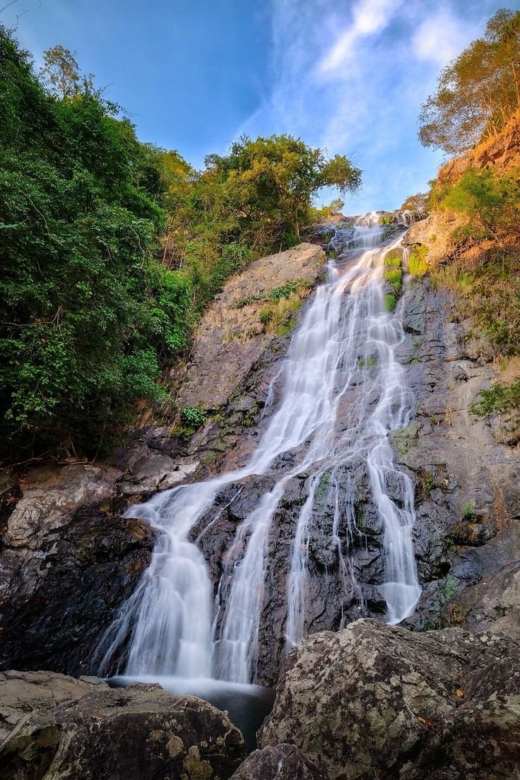This may contain: a large waterfall with lots of water coming out of it's sides in the jungle