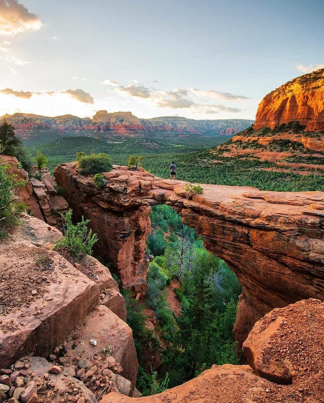 This may contain: the sun is setting over canyons and trees in the valley below it, as seen from an overlook point