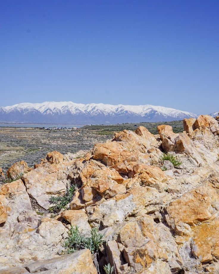 This may contain: the mountains are covered with snow in the distance, and there is no image to describe