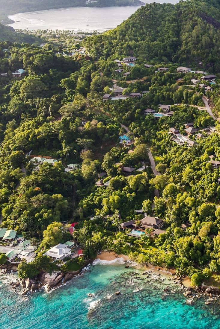 This may contain: an aerial view of the ocean with houses and trees in the area next to it