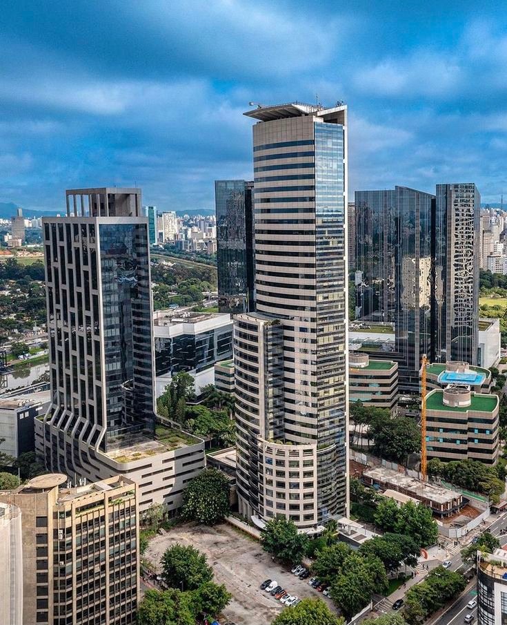 This may contain: an aerial view of some very tall buildings in the middle of a city with lots of trees