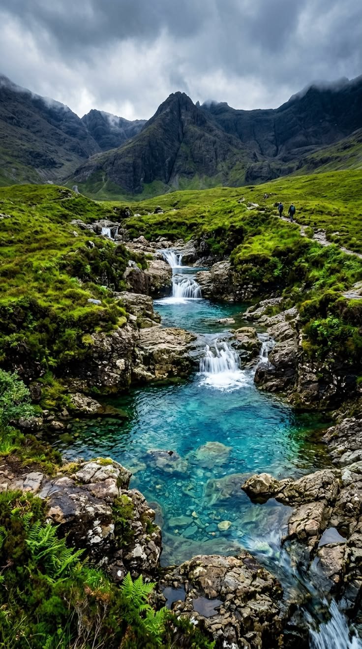 This may contain: a stream running through a lush green valley