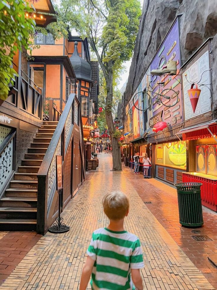 This may contain: a little boy that is standing in the street