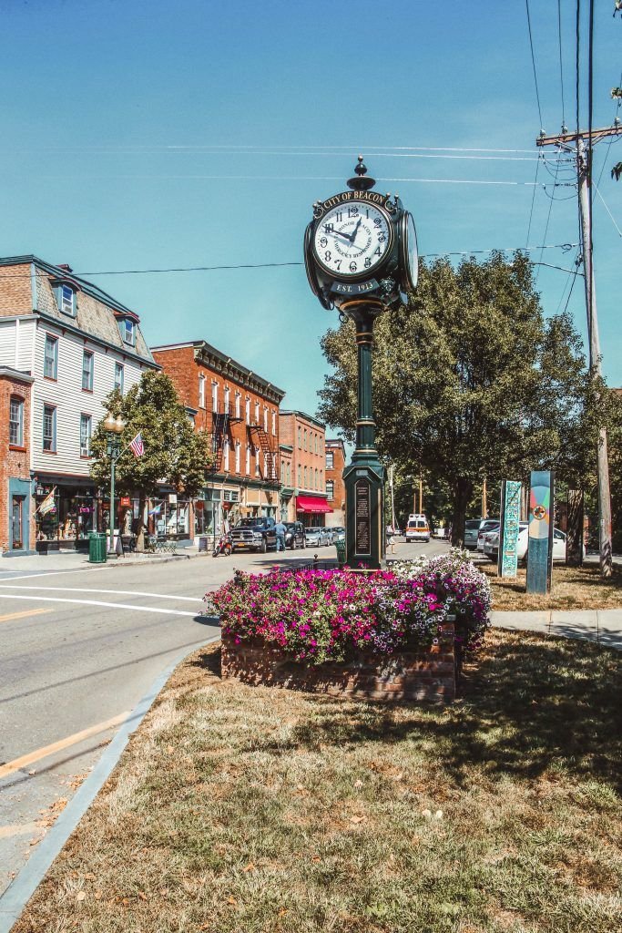 This may contain: a clock on a pole in the middle of a street